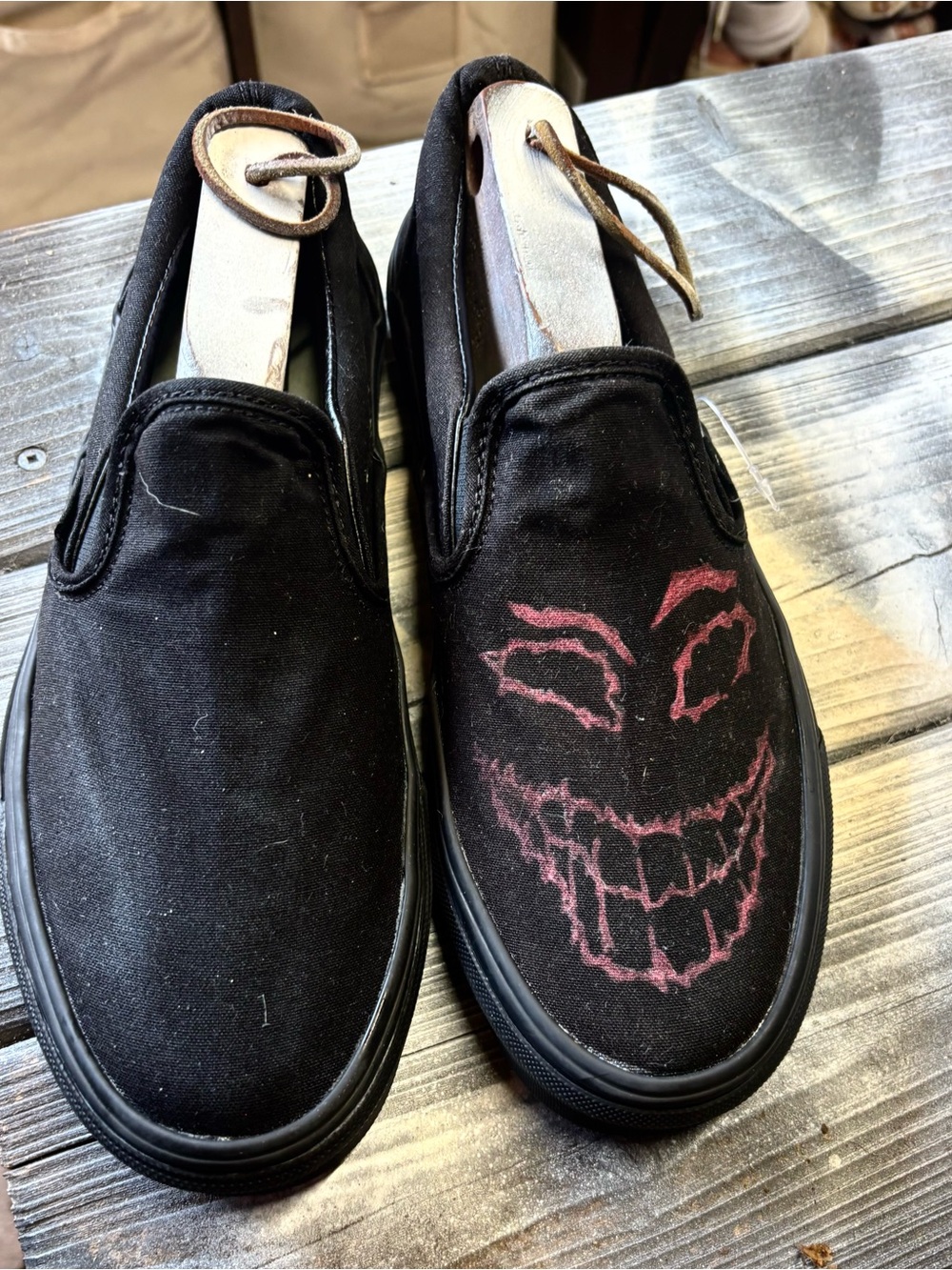 Vans black slip-on canvas sneakers with red hand-painted smiley face